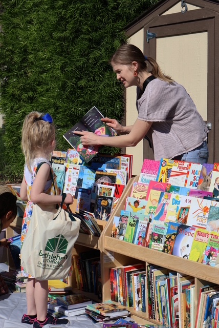 woman teaching kids with a book