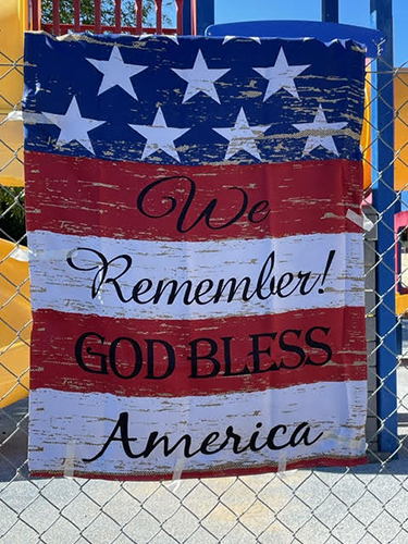 American flag poster with written words 'We Remember and God Bless America'